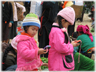 Two small girls in pink looking at their phones.