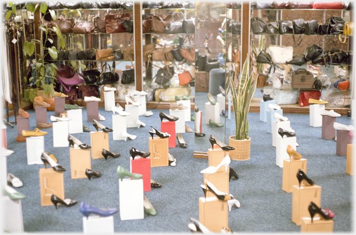 Window of shoe shop with extensive display.