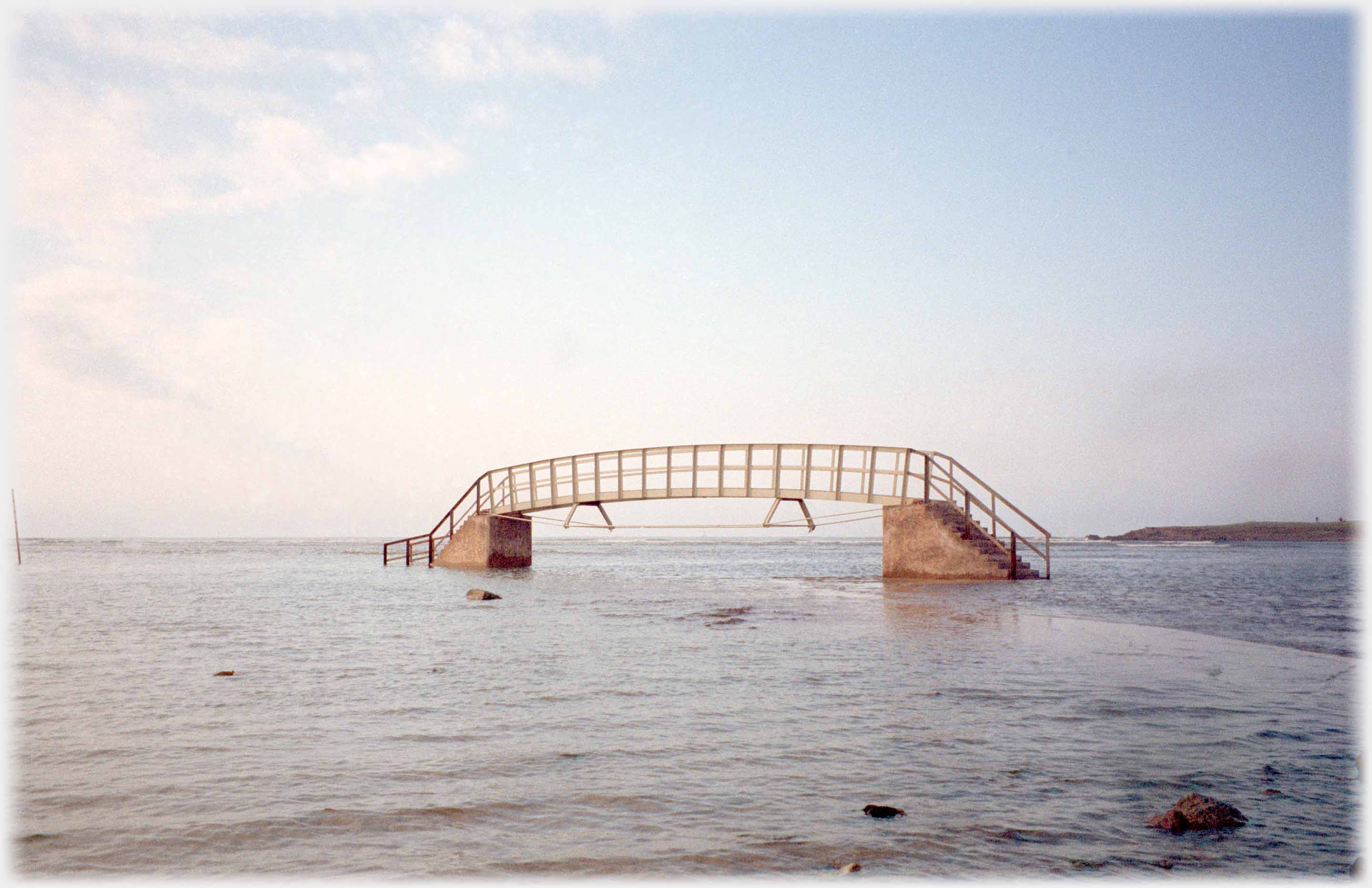 Bridge with steps up out of the sea either end.