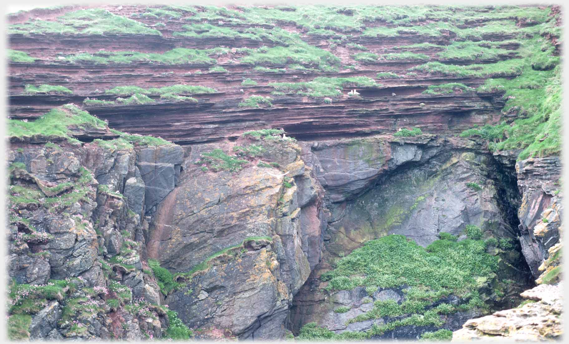 Fragmented boulders with layered horizontal rocks sitting on them.