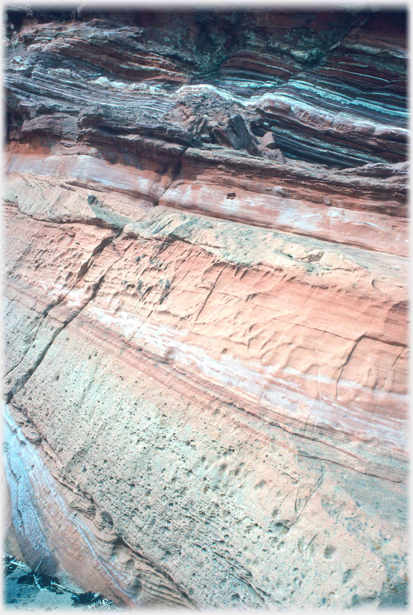 Many complex layers and colours in a rock face.