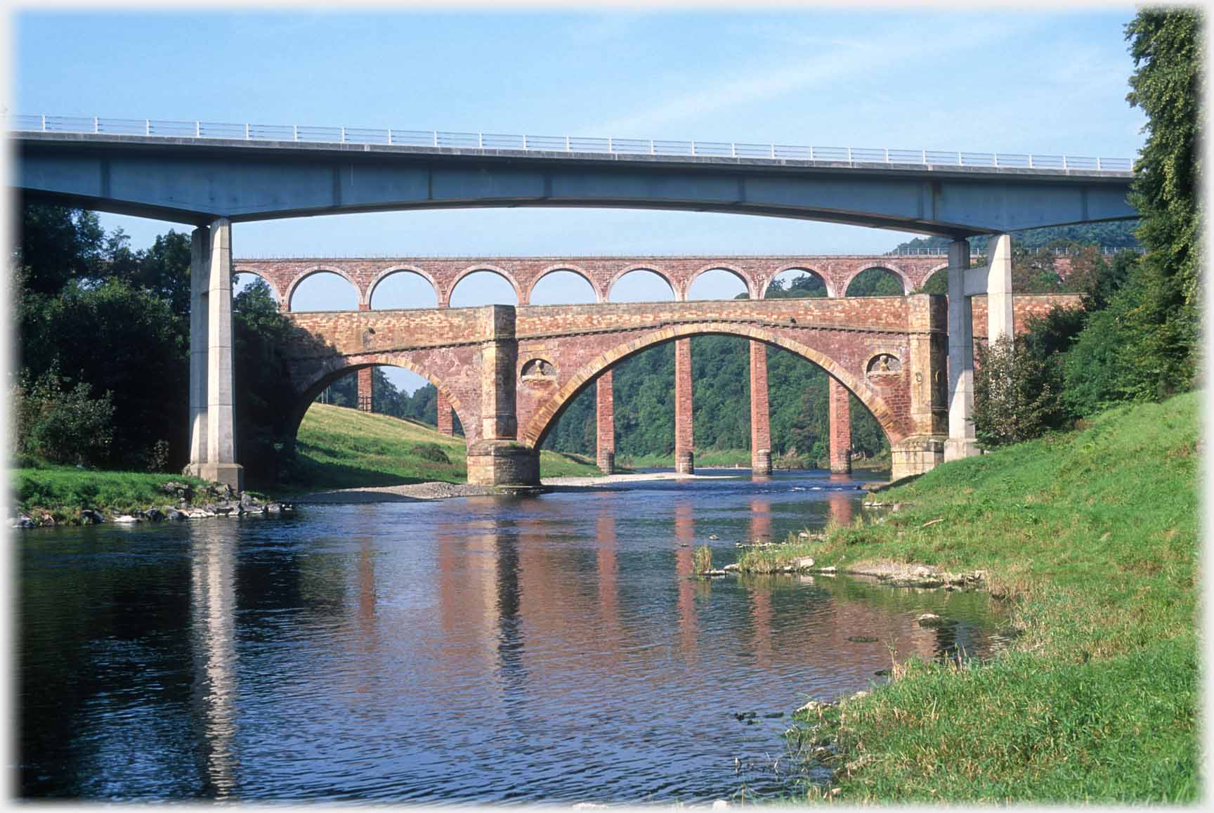 Looking through arch of modern bridge to the two older bridges beyond.