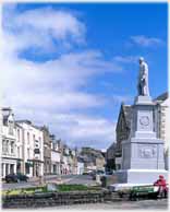 Statue on plinth by shopping street.