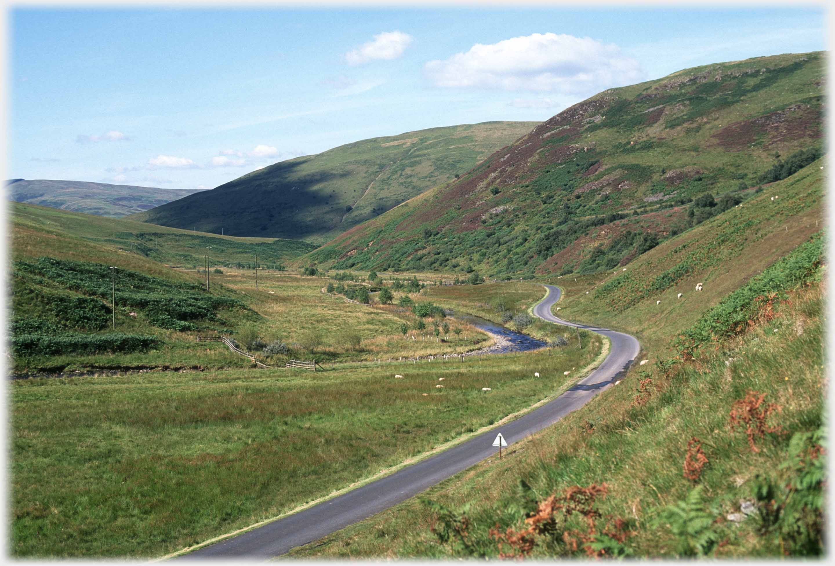 Winding valley with road and river.