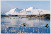 Snow covered hills and frozen loch.