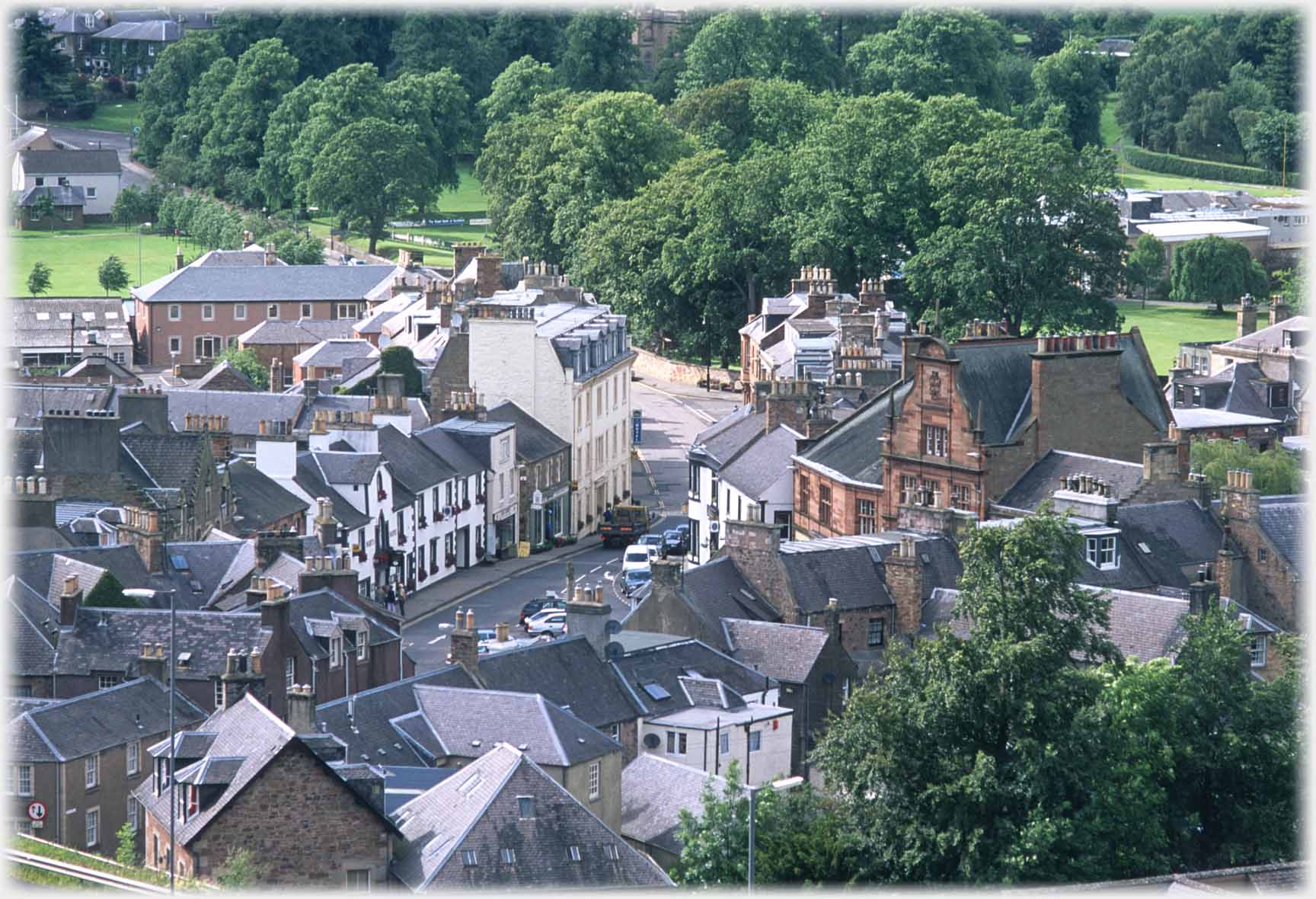 View down between houses on wide street.