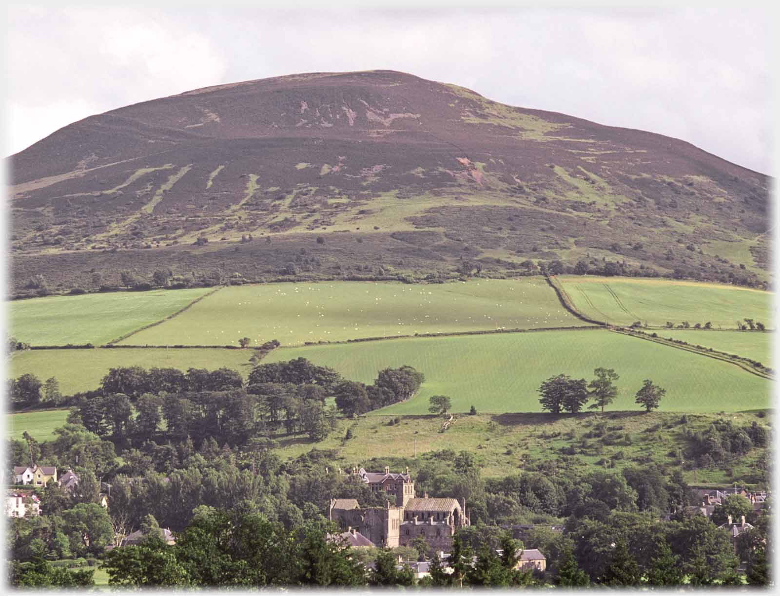 Hillend with fields and abbey in foreground.