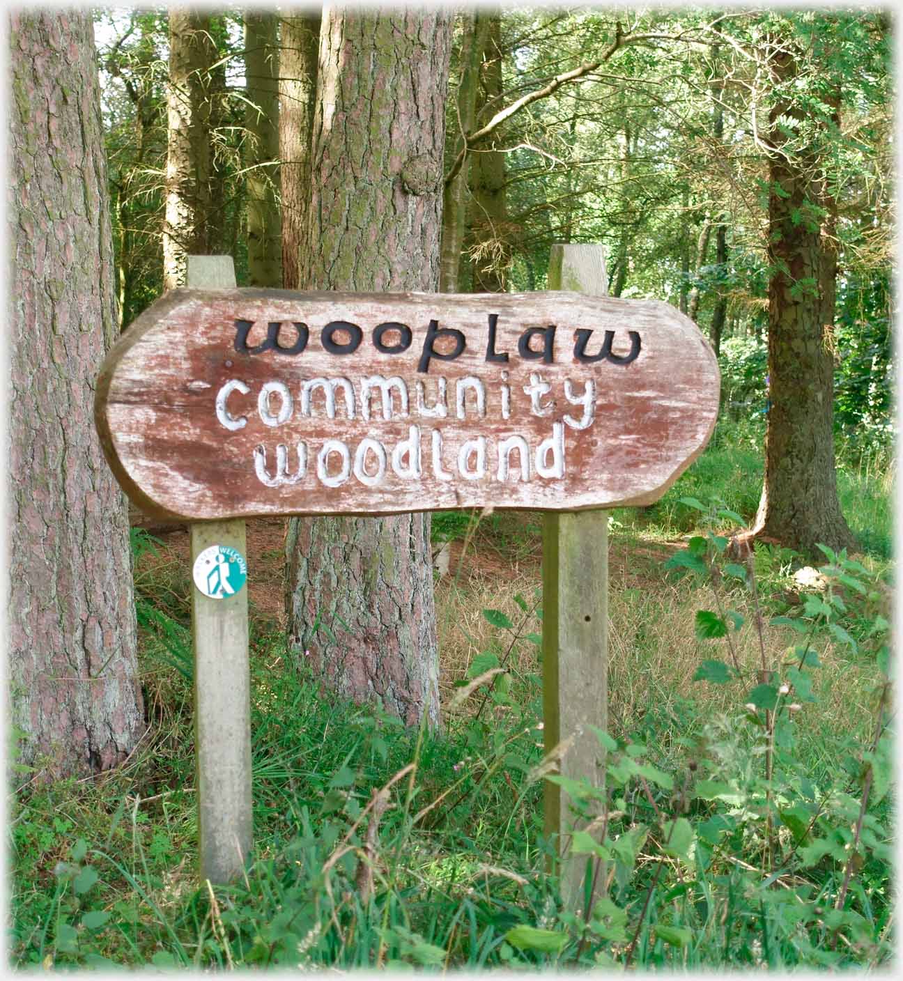 Wooden sign saying wooplaw commnity woodland