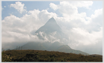 Pointed peak between clouds.