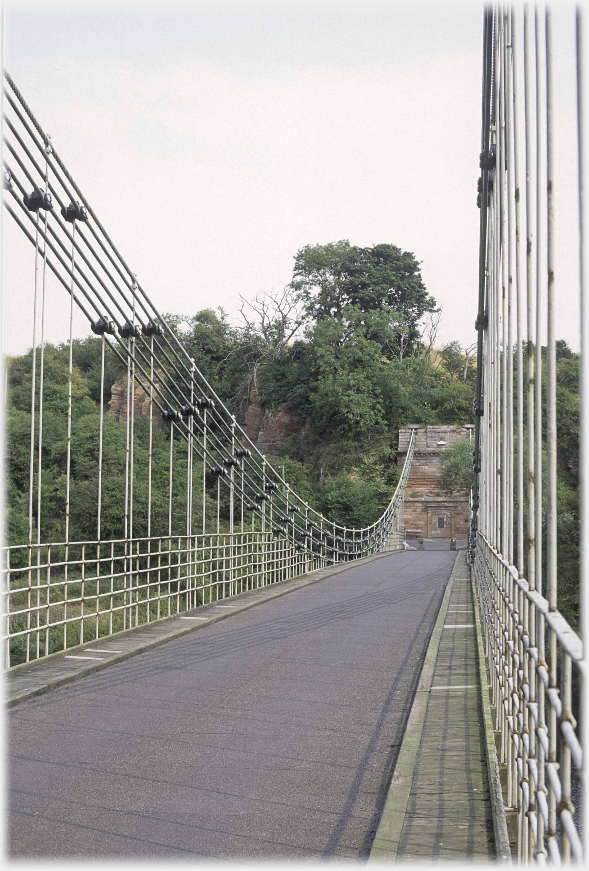 On a suspension bridge with the curve of the cables on one side and the vertical supports on the other.