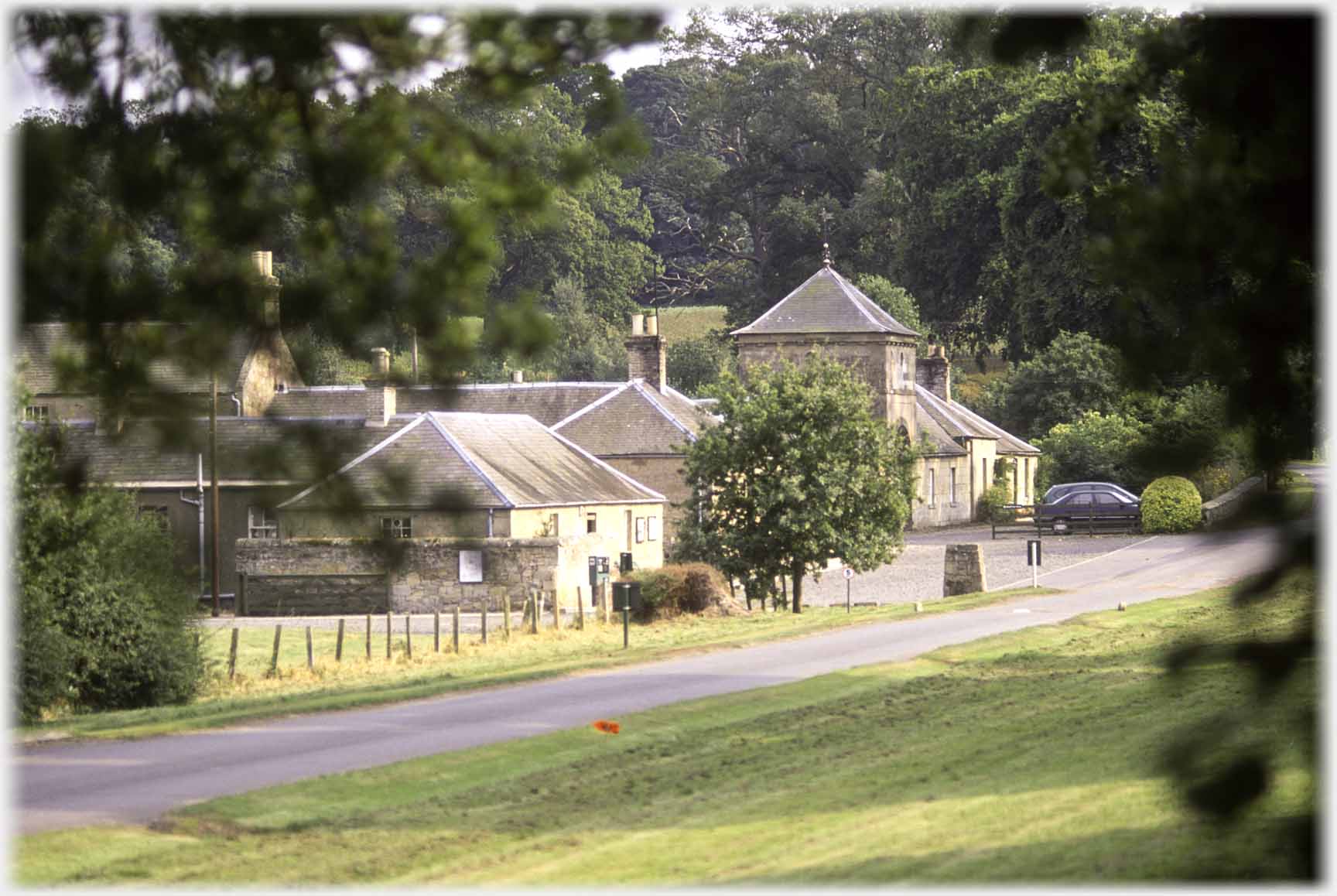 Group of buildings across grassed area.