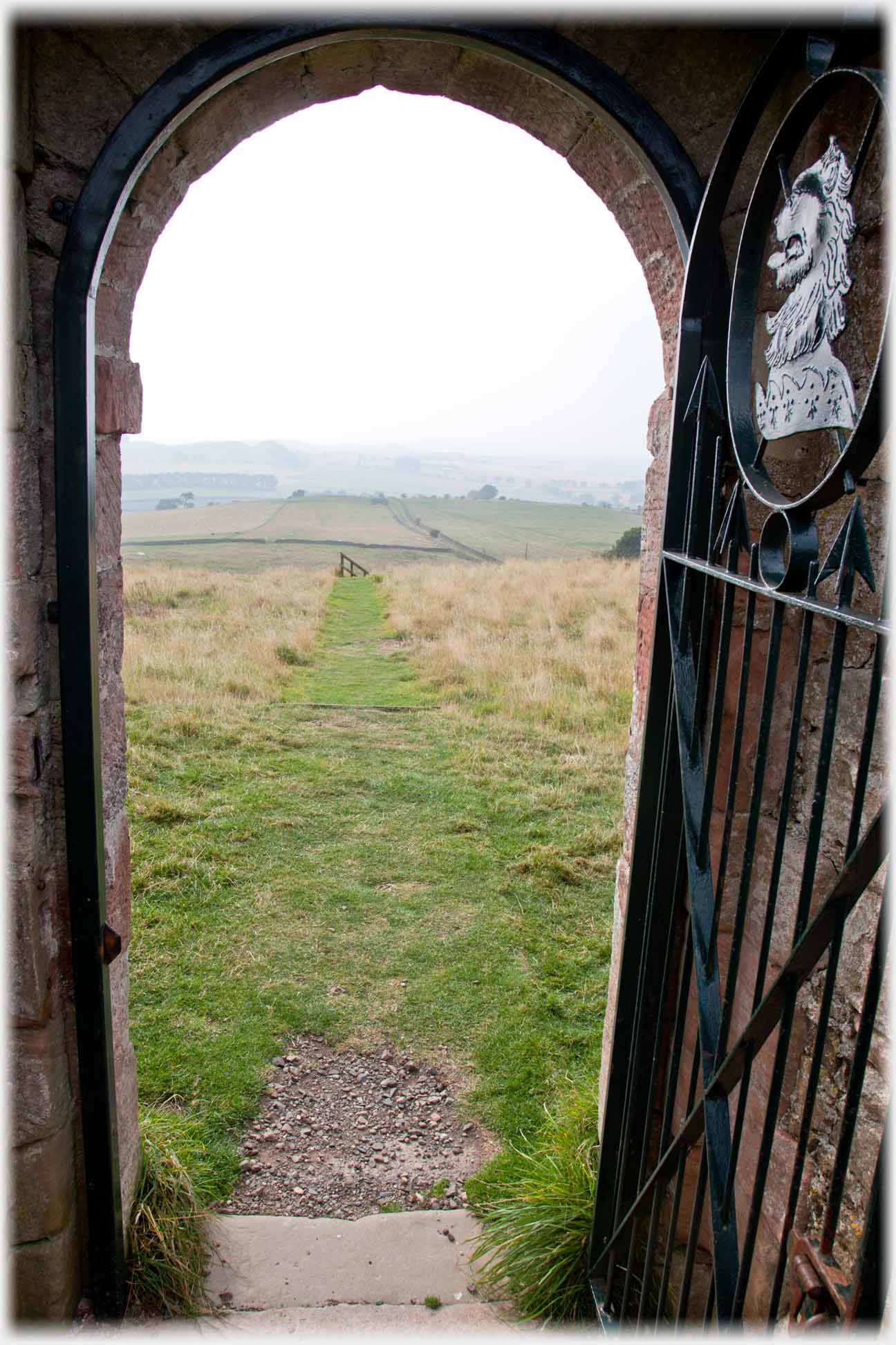 Looking out of a gate on which the Home crest appears.