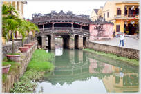 Covered wooded bridge over canal.