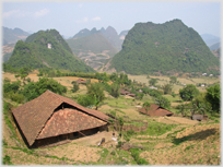 Large houses with tiled roofs and tree covered karsts.