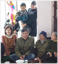 Family sitting and standing at meal.