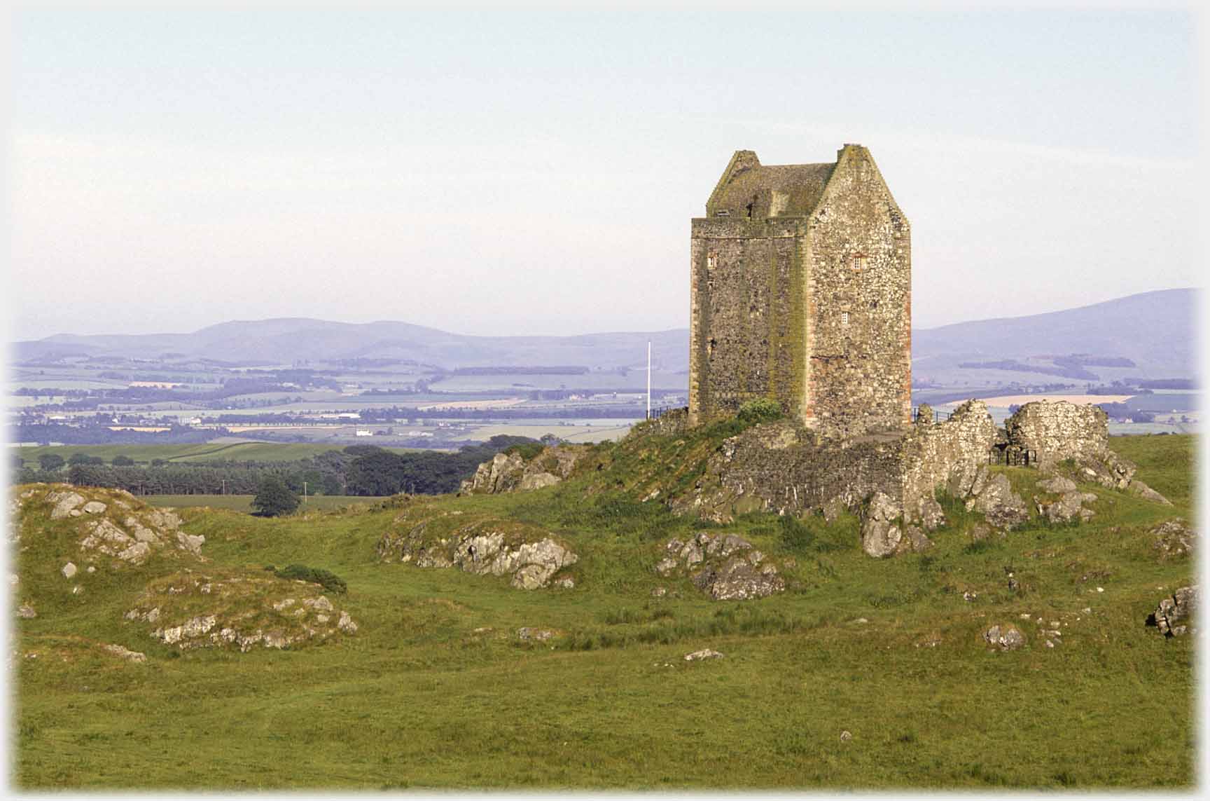 Tower house to right, distant hills.