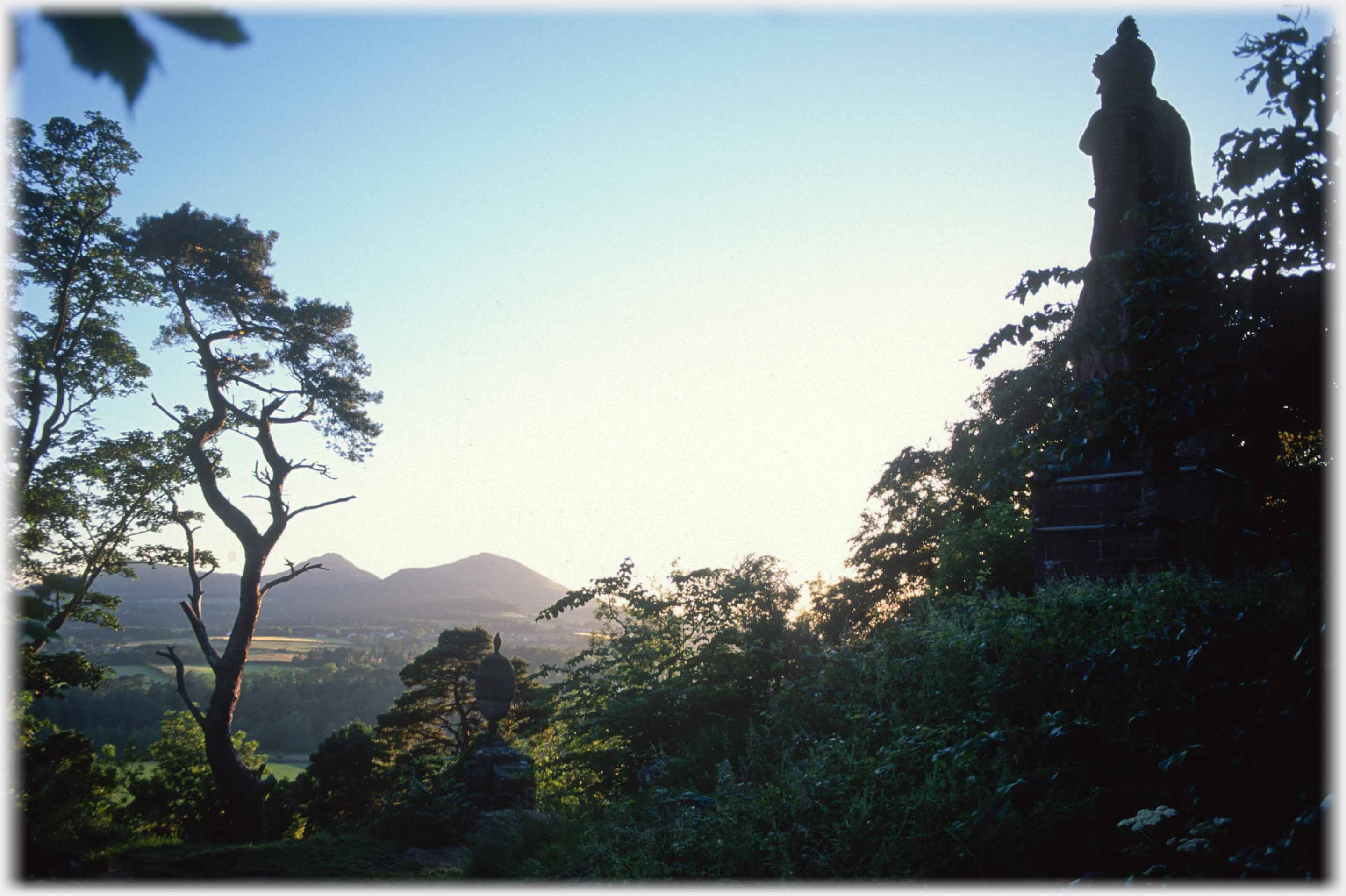 Silhouette of large statue looking towards Eildon hills.