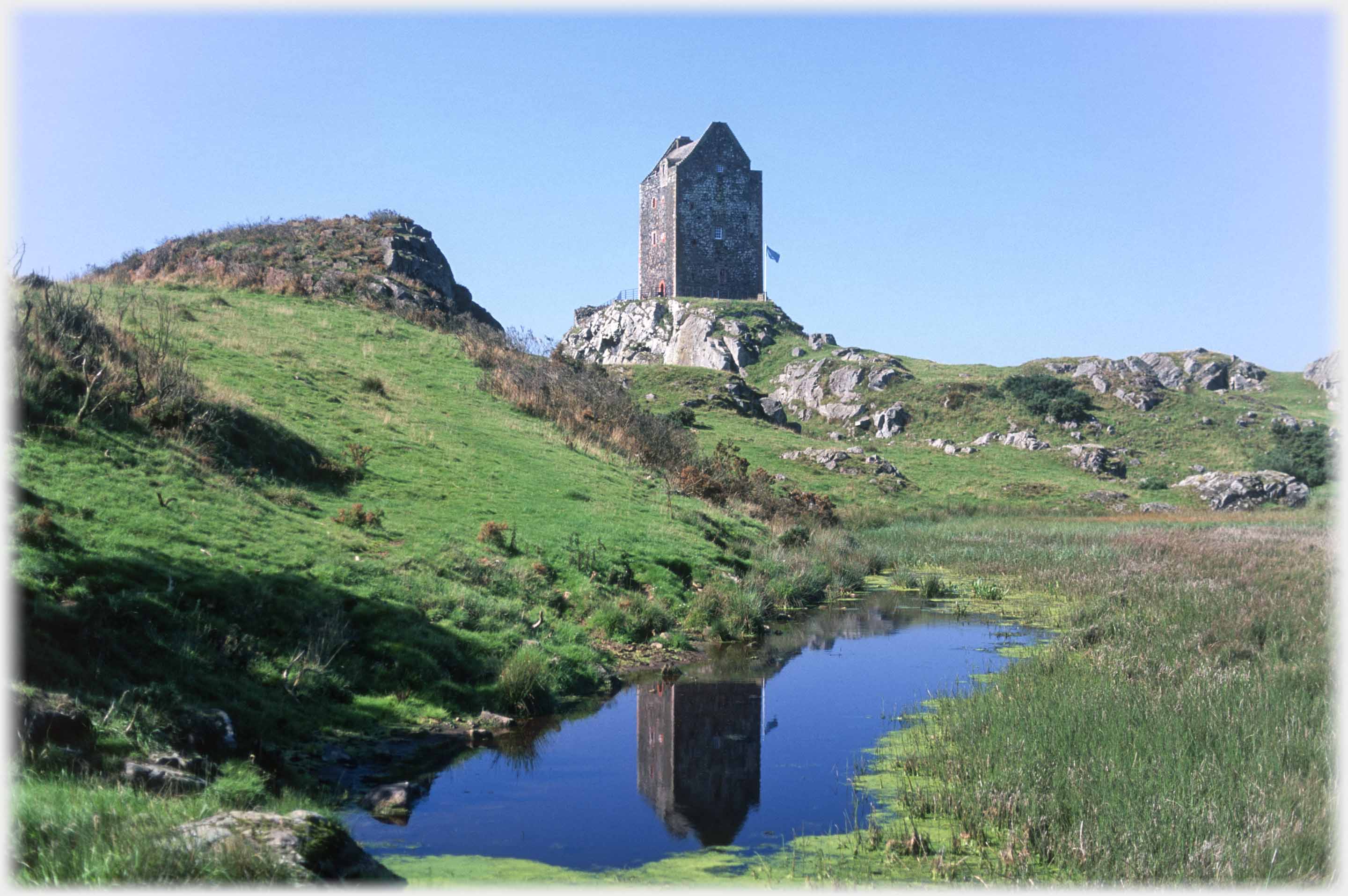 Tower house with small pool nearer the camera.