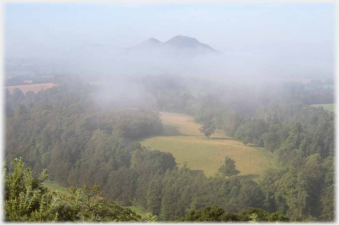 Hills and fields nearly visible except for band of cloud.