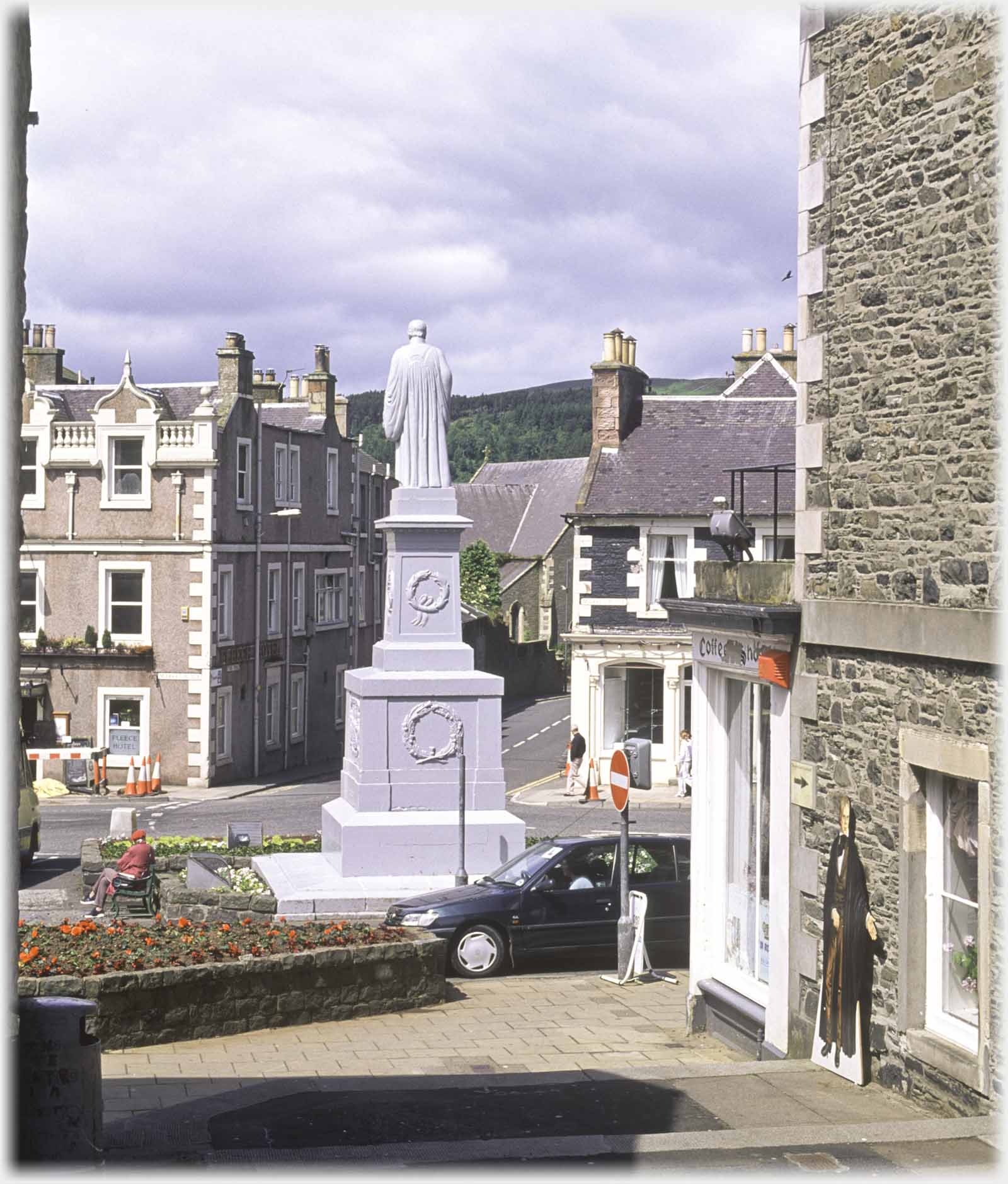 Back of statue on plinth which is looking down road opposite, cut out against wall on right.