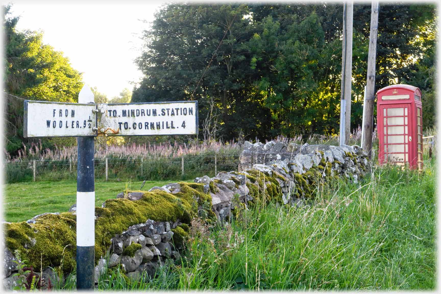 Old signpost to station, telephone box.