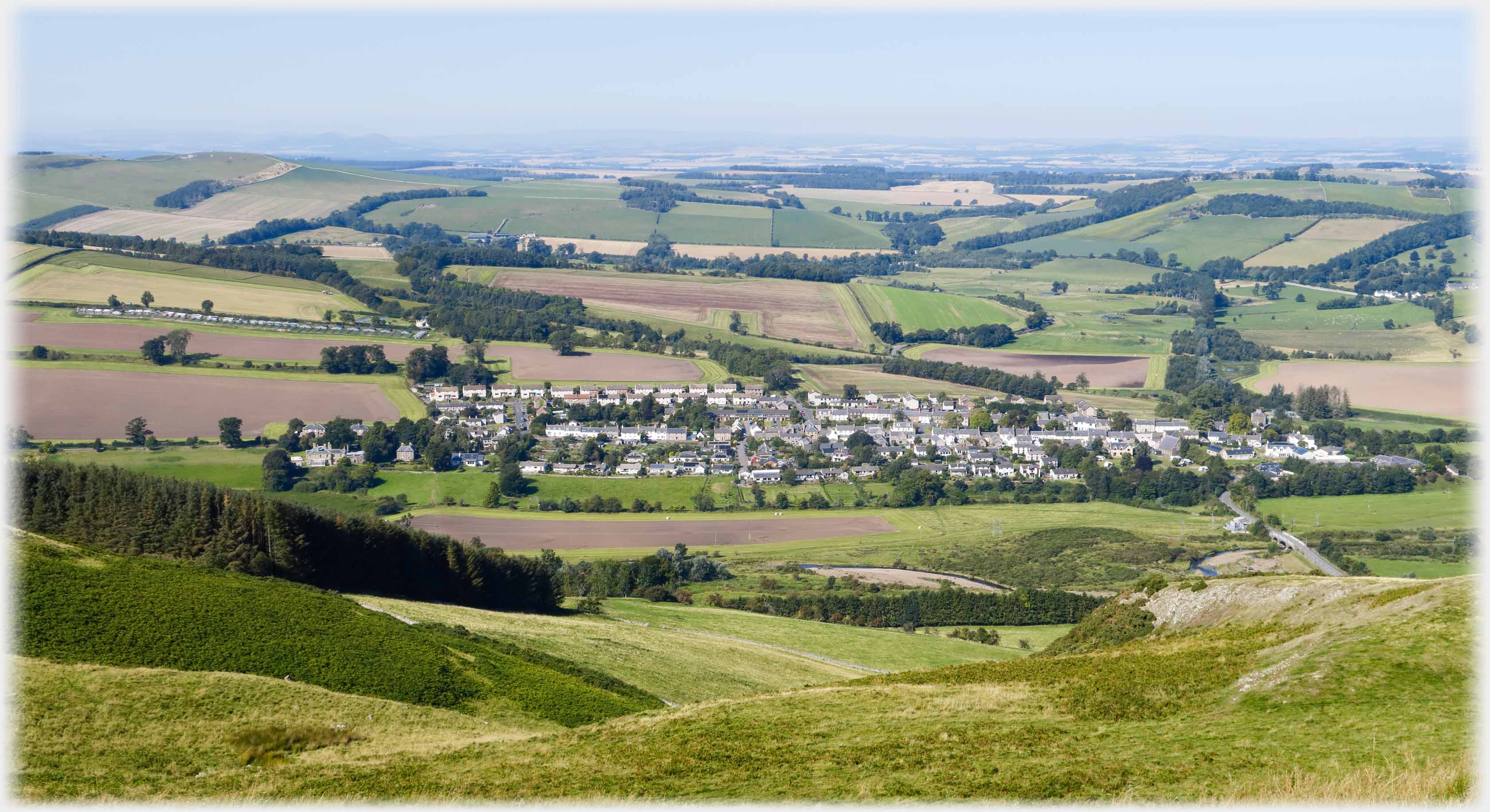 Same packed houses but with much wider view showing plain extending away.