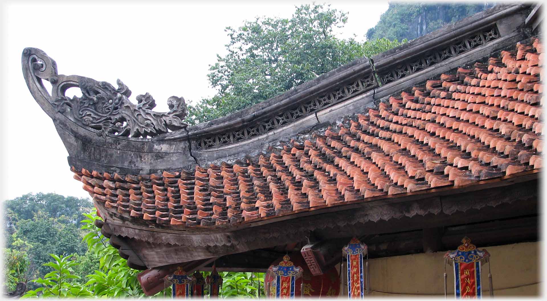 Corner of roof with styalised decoration and cracks between roofing stones.