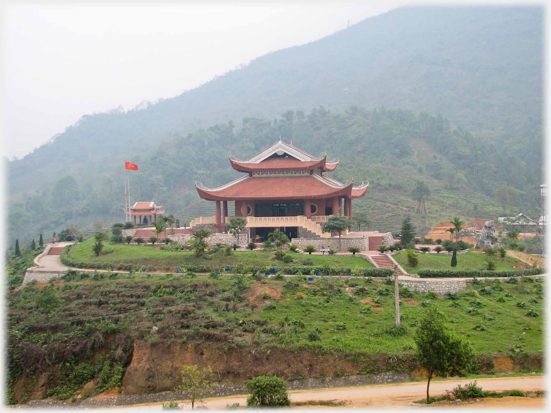 Temple complex with gardens on plateau by hill.