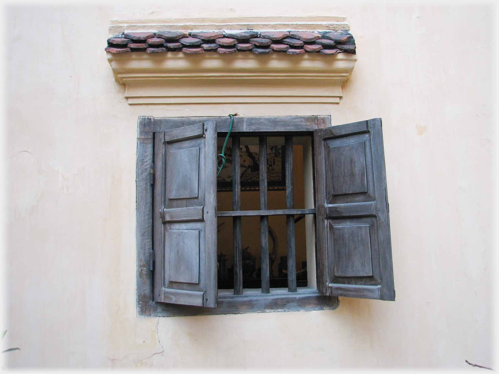 Small barred window with shutters.