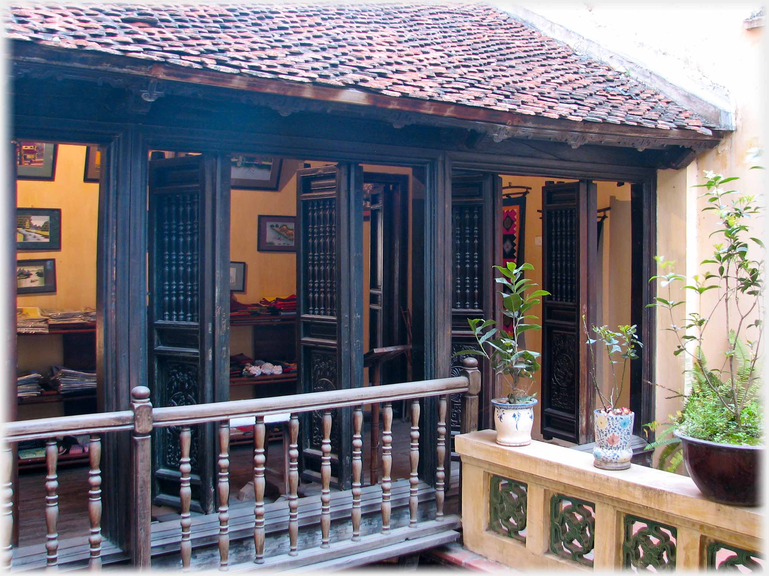 Small balcony with set of 10 doors standing open.