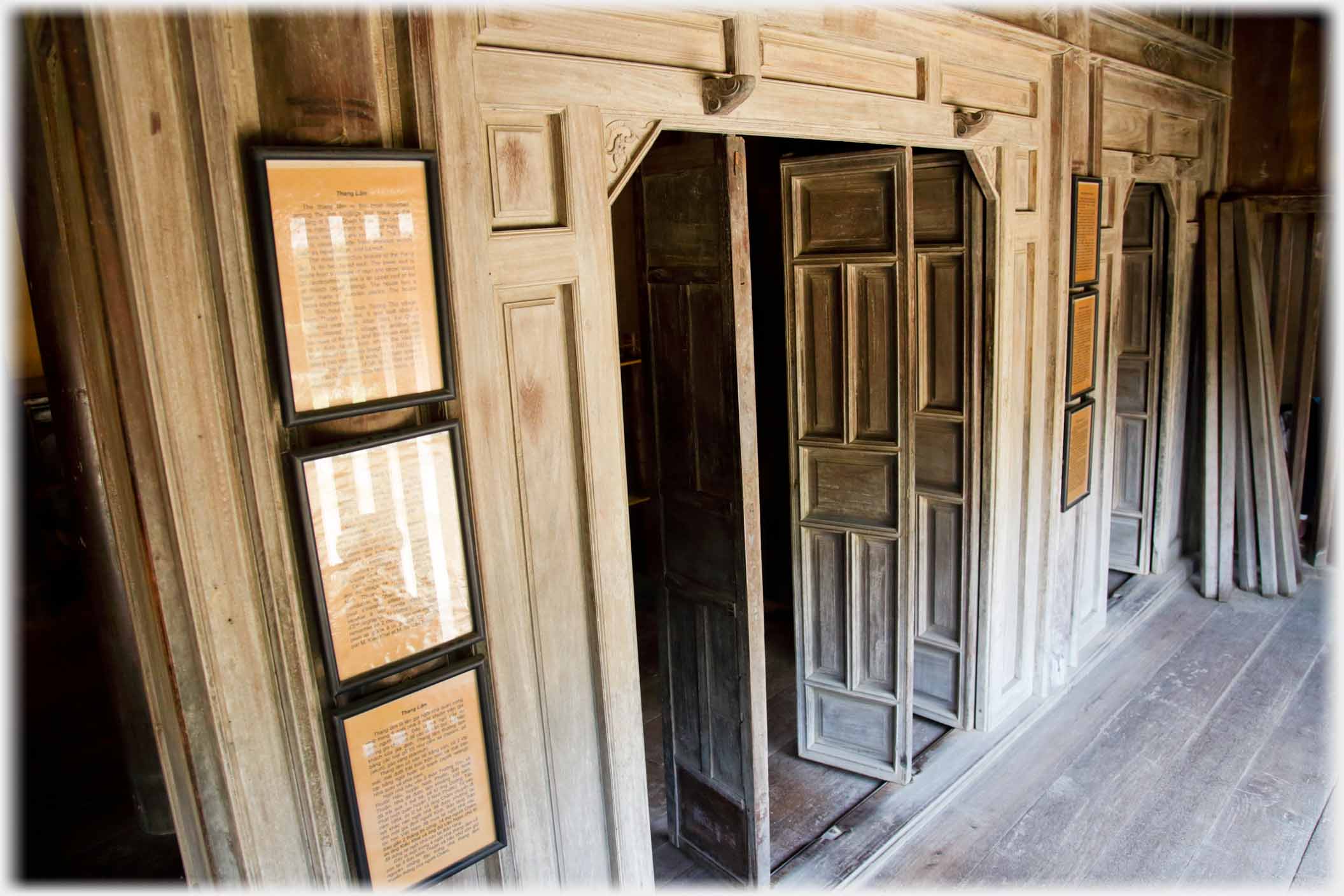 Untreated wood doors and surrounds with stack of wood beyond