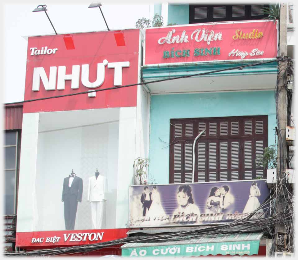 Upper large window  with men's suits next to balcony.