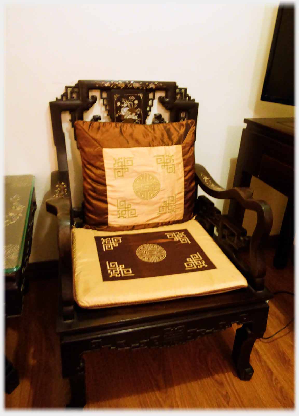 Chair with similar geometric pattern on cushions and carved in back.