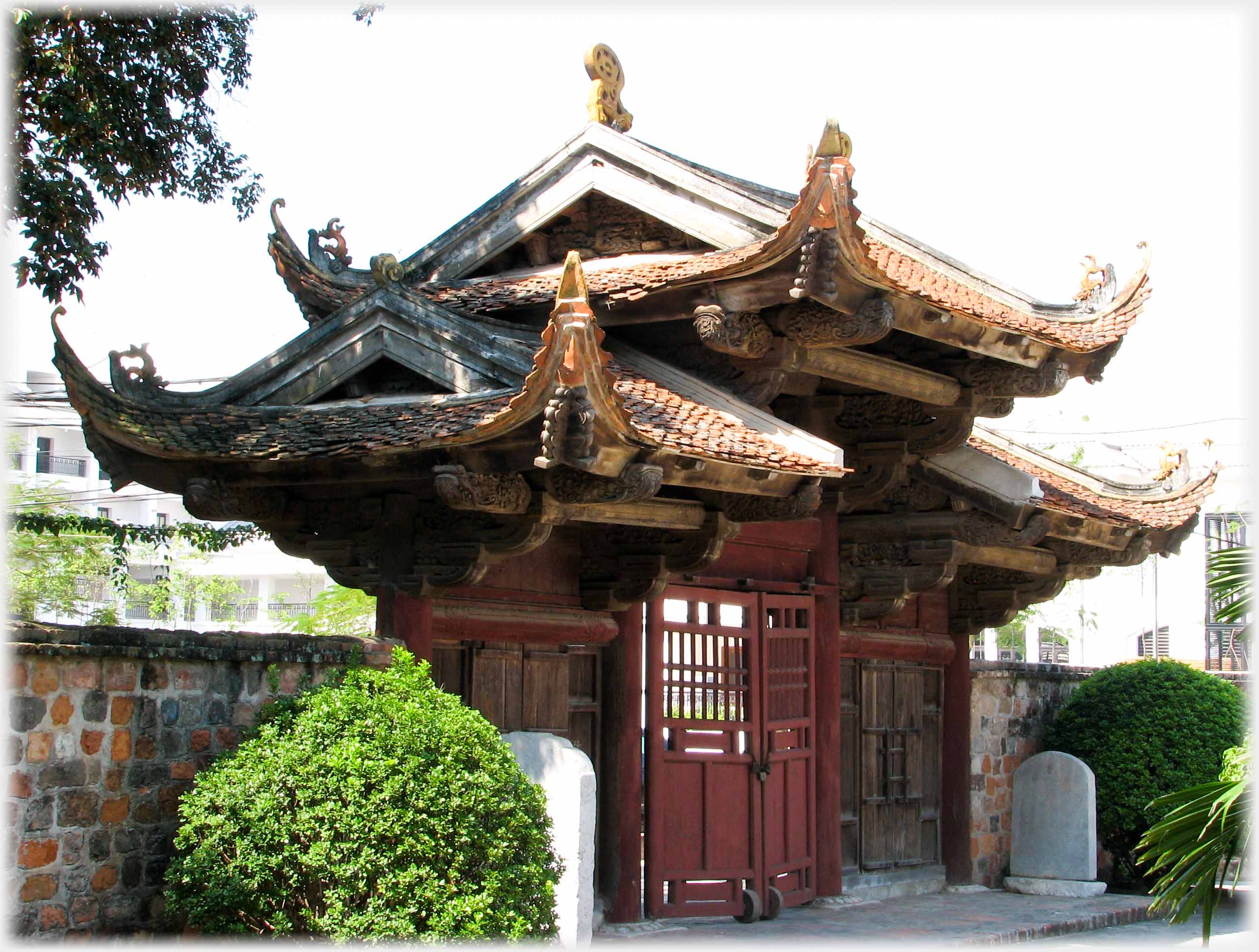 Gate with doors and complex triple roof with upturned corners.