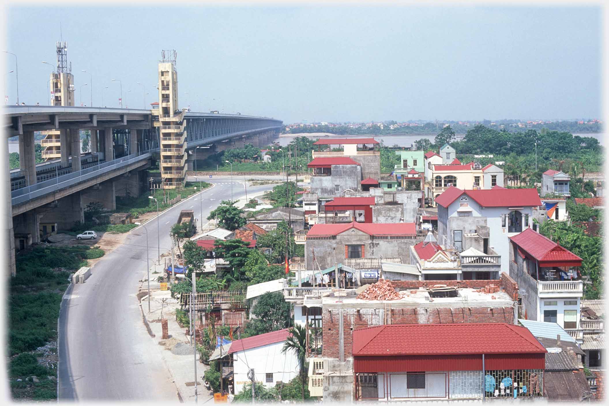 Two decker bridge at right, road and houseing main area of photo.