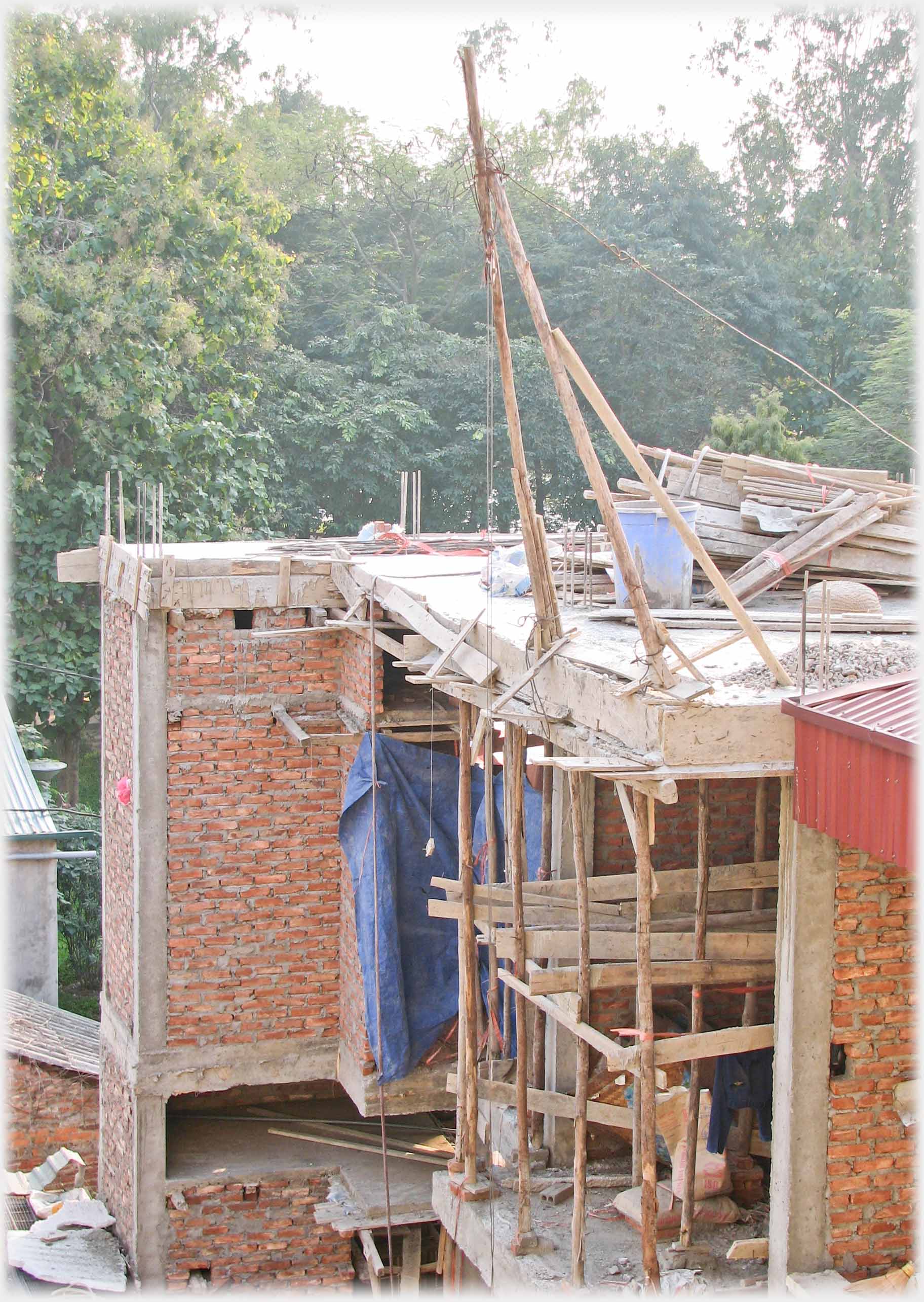 Houses under construction, wooden pulley and scaffolding.