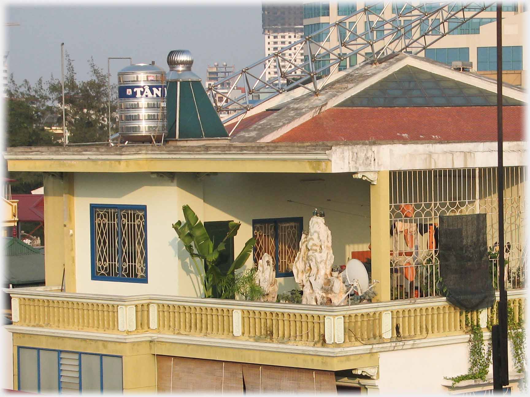 Jumble of roofs with twin towers beyond, covered balcony on near roof