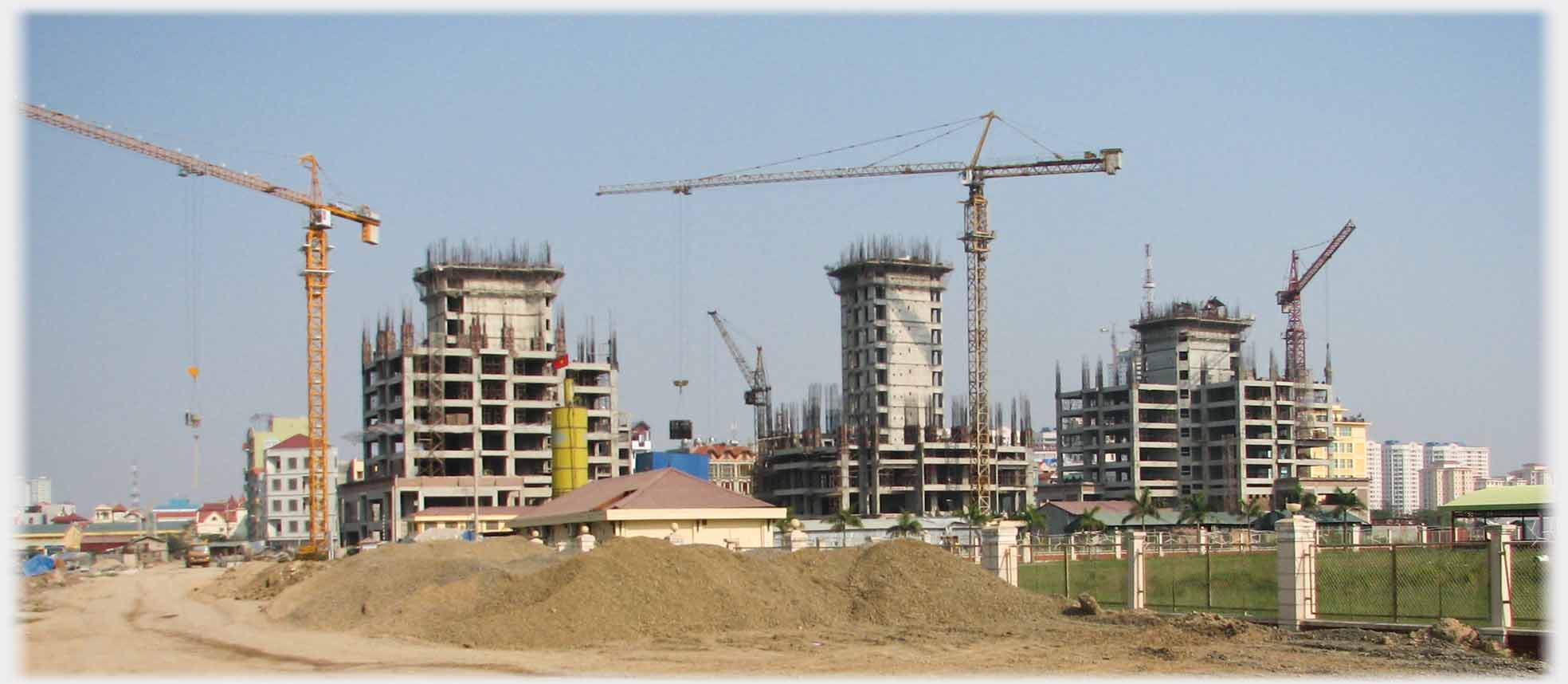 Tower blocks under constructon with cranes over them.