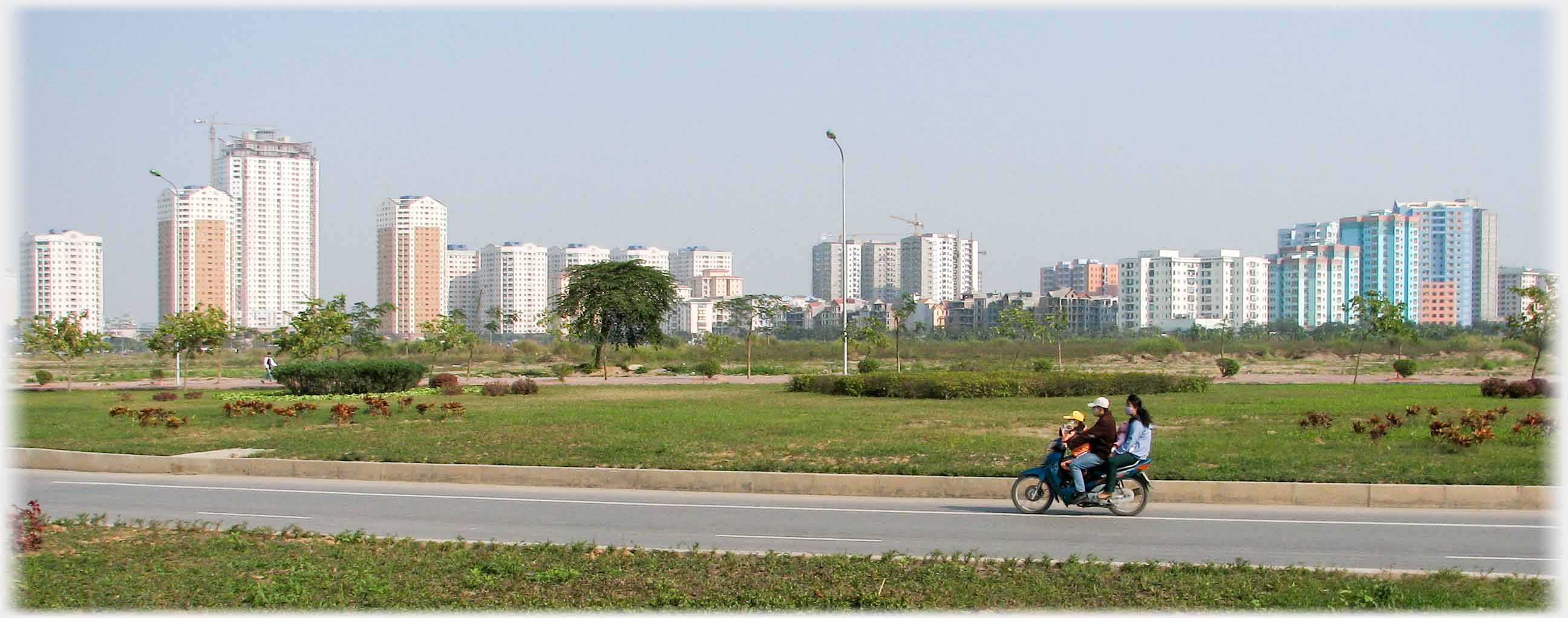 Road lined with tower blocks into the distance.