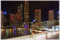 Night shot of tower blocks and water in central Singapore.