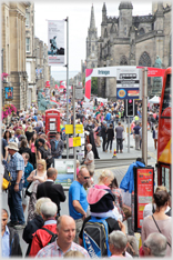 Looking down street which is packed with people.