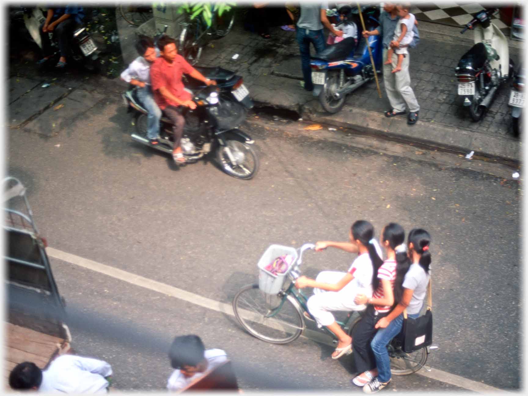 Three girls on pedal cycle.