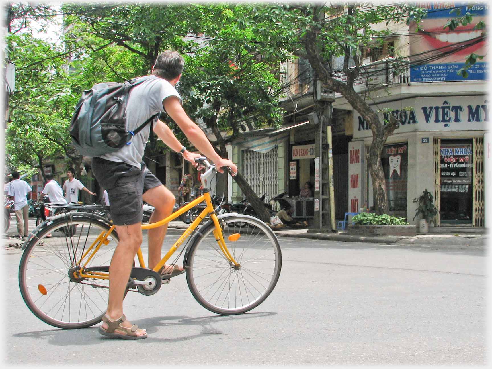 Western man stopped on bicycle.