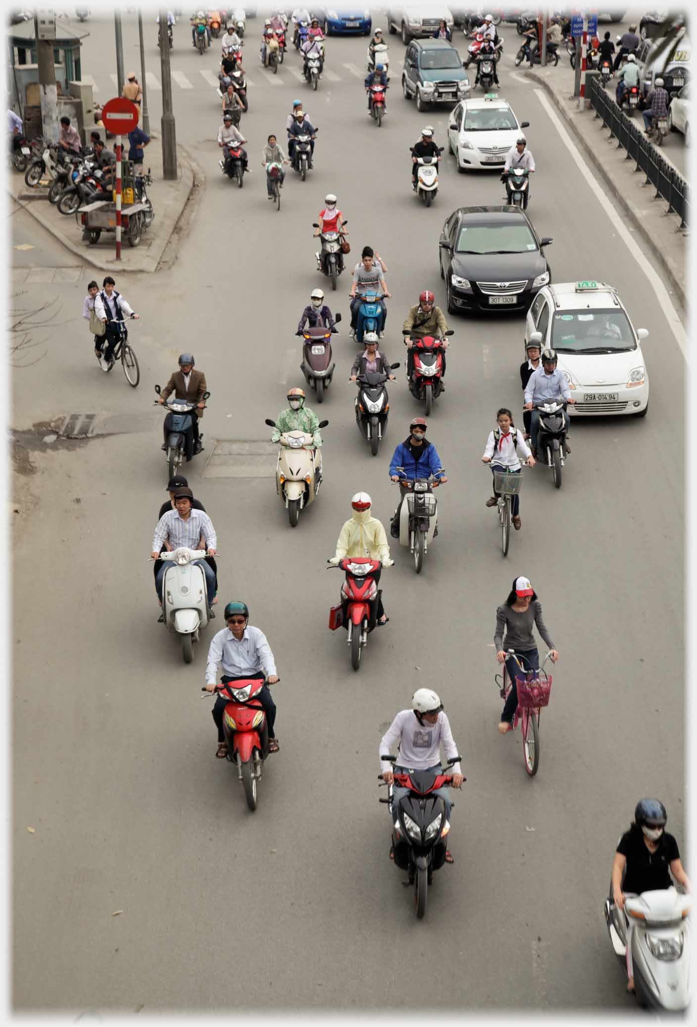 Motorbikes spaced out along road seen from above.