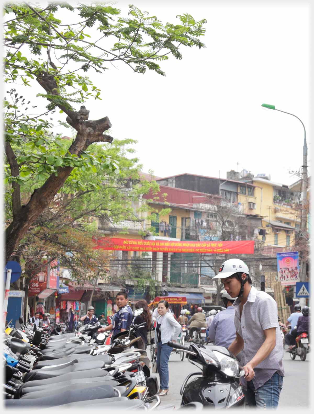 Man parking motorbike at row of bikes.