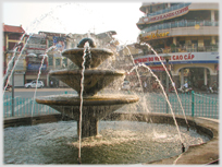 Water fountain with buildings beyond.