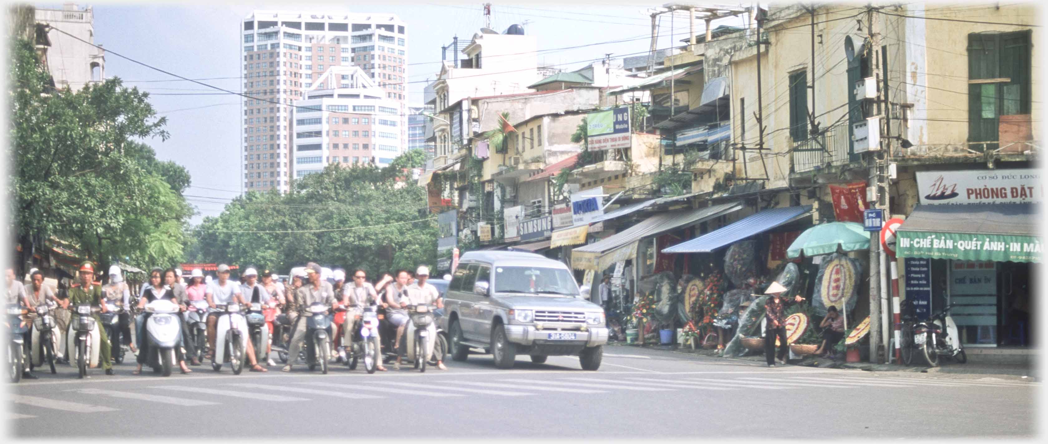 Line of traffic waiting at lights. Tower block in background.