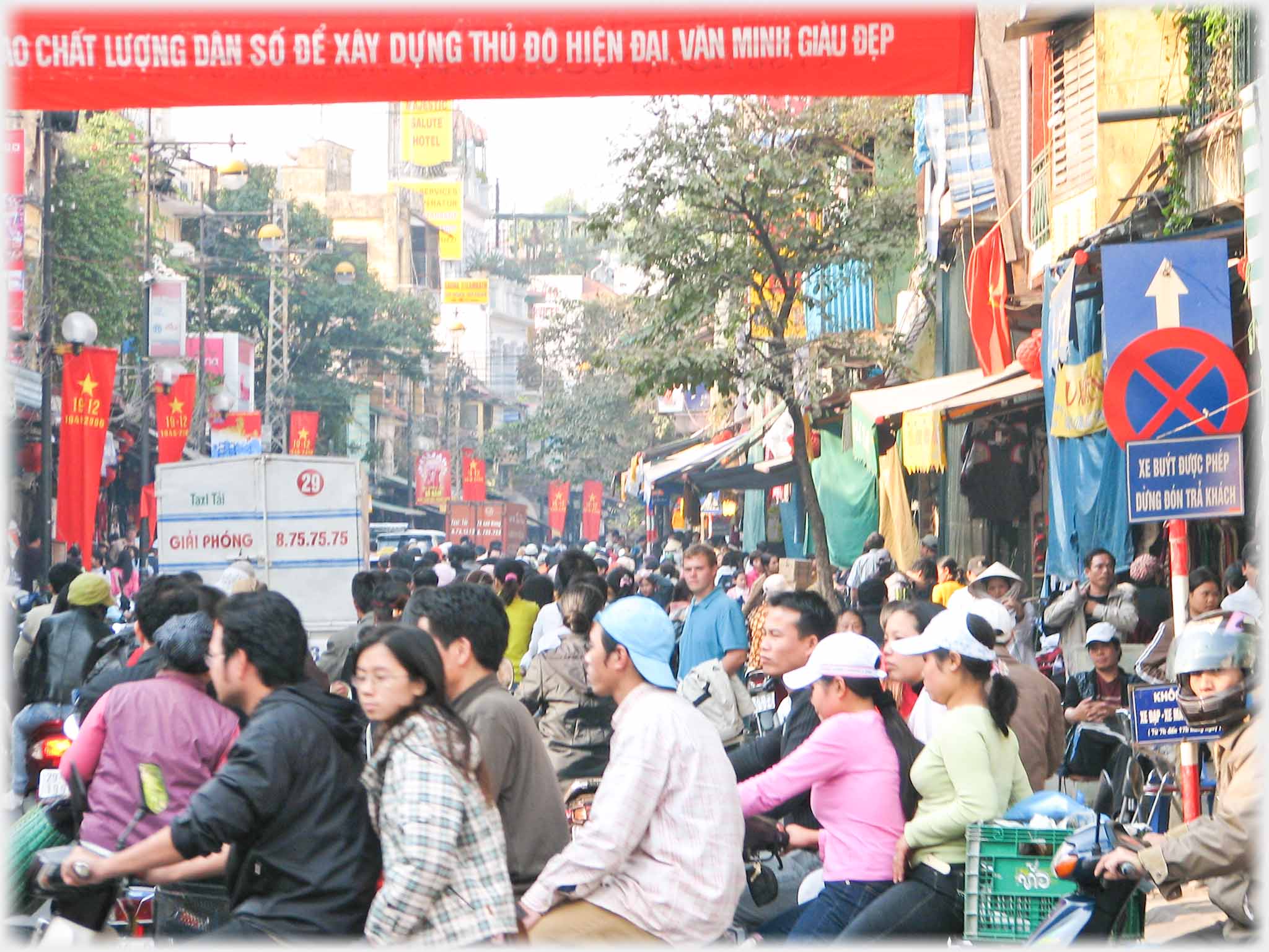 A street solid with motorbikes some at an angle to others, a pedestrian standing out.