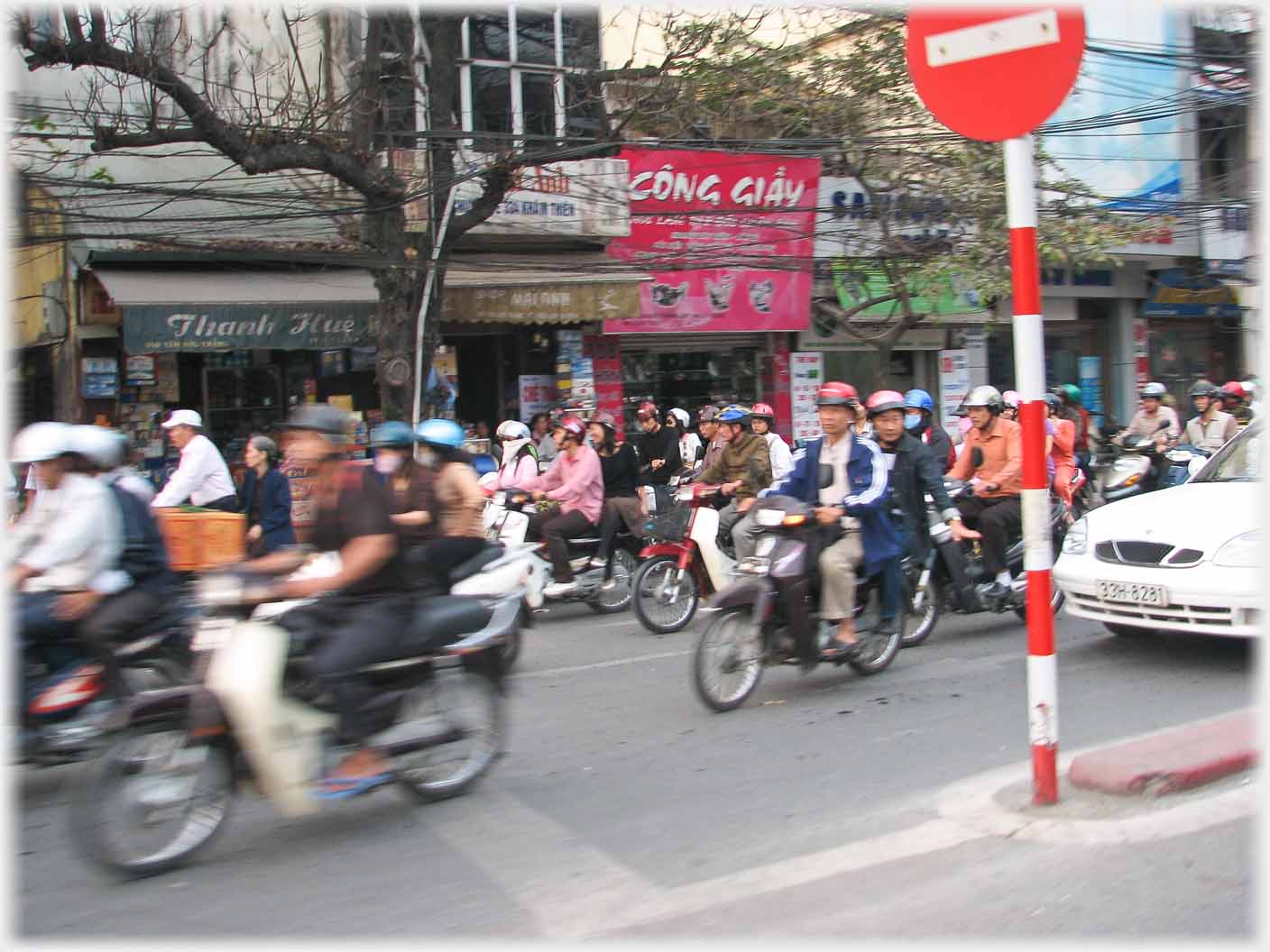 Motorbike turning in front of car with pillion indicating to car to give way.