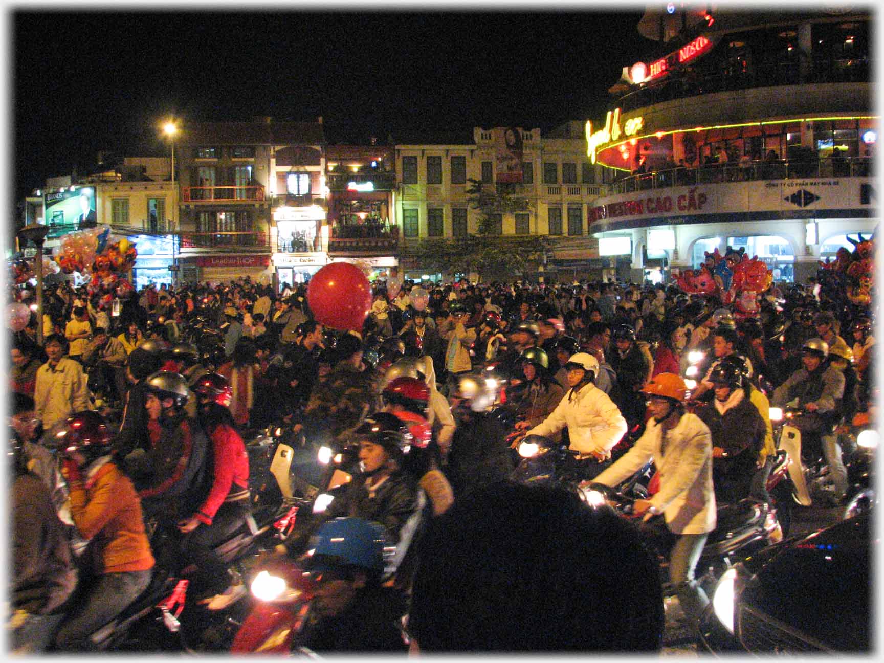 Crowds on motorbikes in large square.